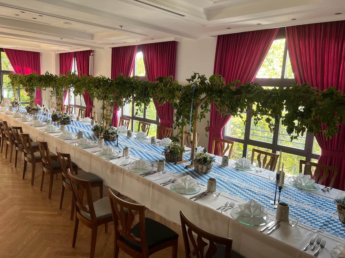 Bayerisch dekorierte Festtafel mit Hopfengirlanden und blau-weisser Tischdecke