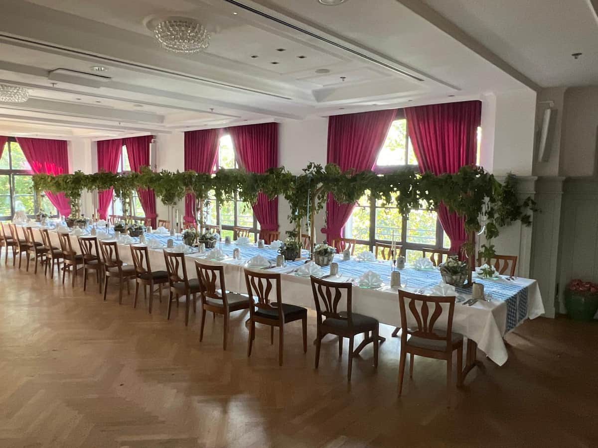 Gesamtansicht des bayerisch dekorierten Festsaals mit langer Tafel