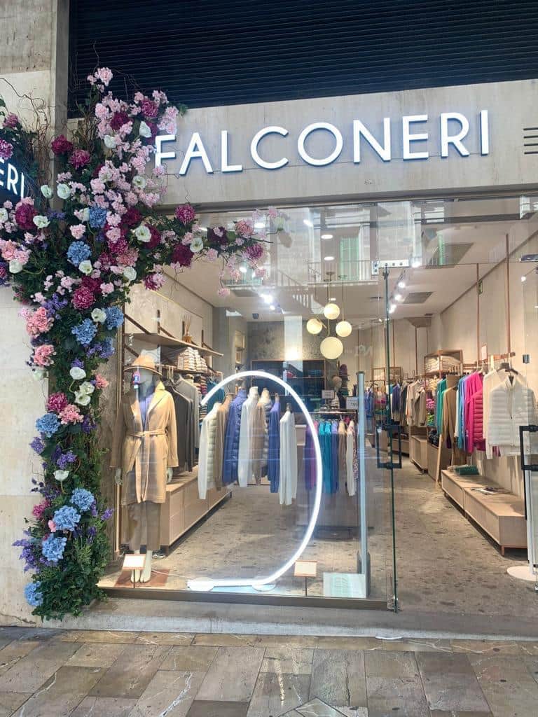 Ueppige Blumeninstallation am Boutique-Eingang mit rosa und blauen Hortensien