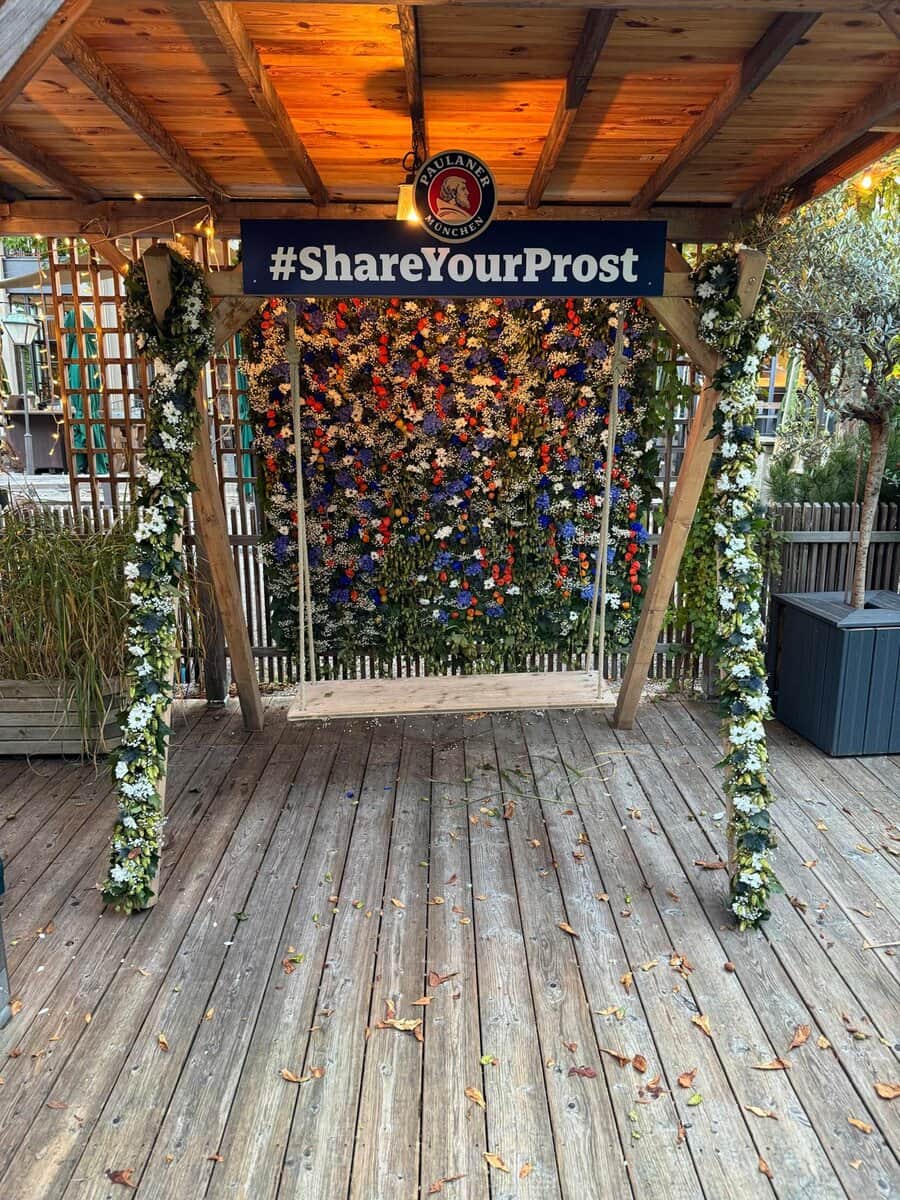 Blumenschaukel mit bunter Blumenwand als Fotospot bei Firmenevent