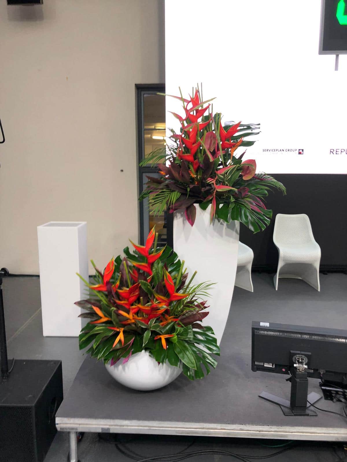Tropische Blumenarrangements mit Helikonien und Palmen fuer Firmenevent