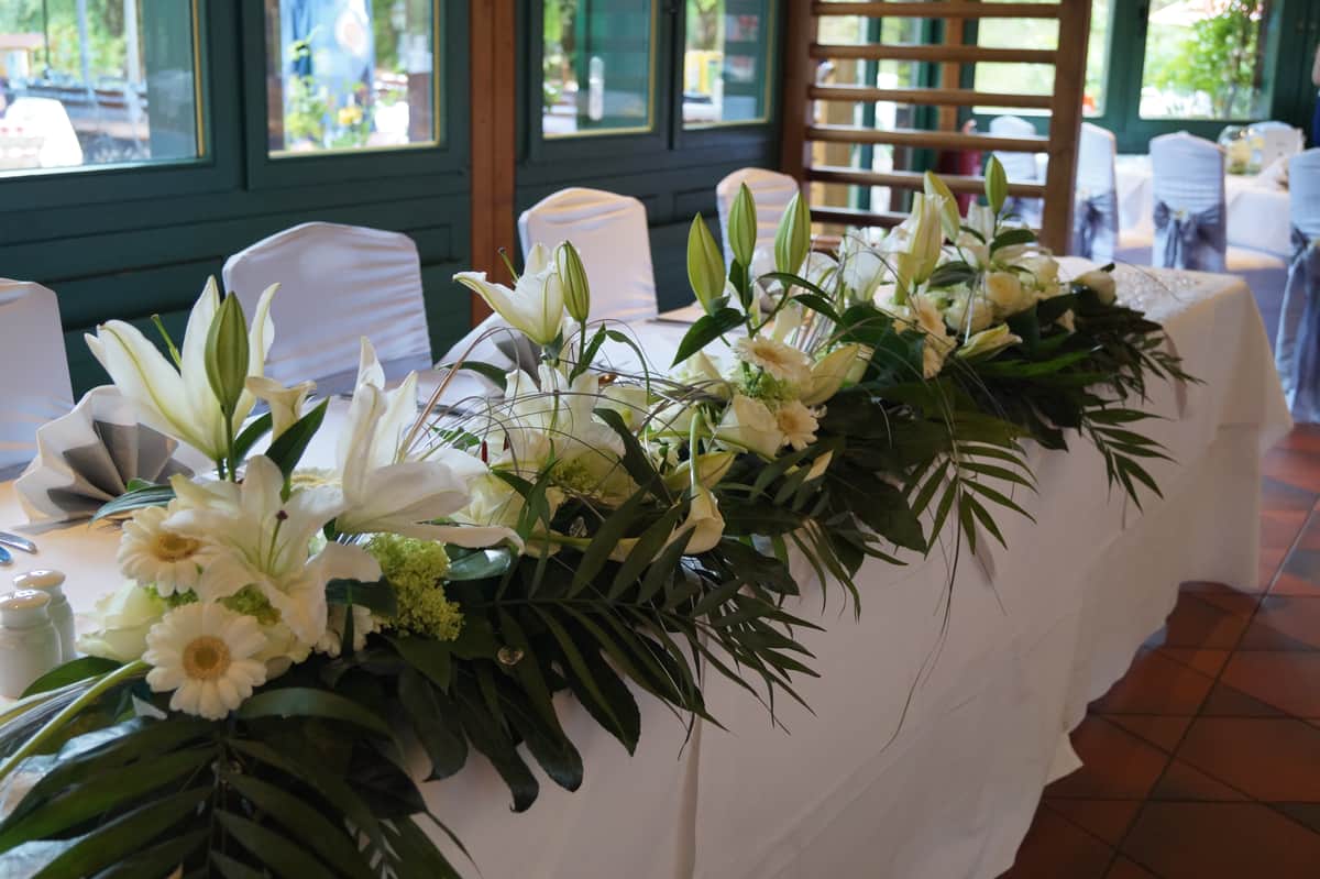 Brautpaartisch mit weißen Lilien und Gerbera
