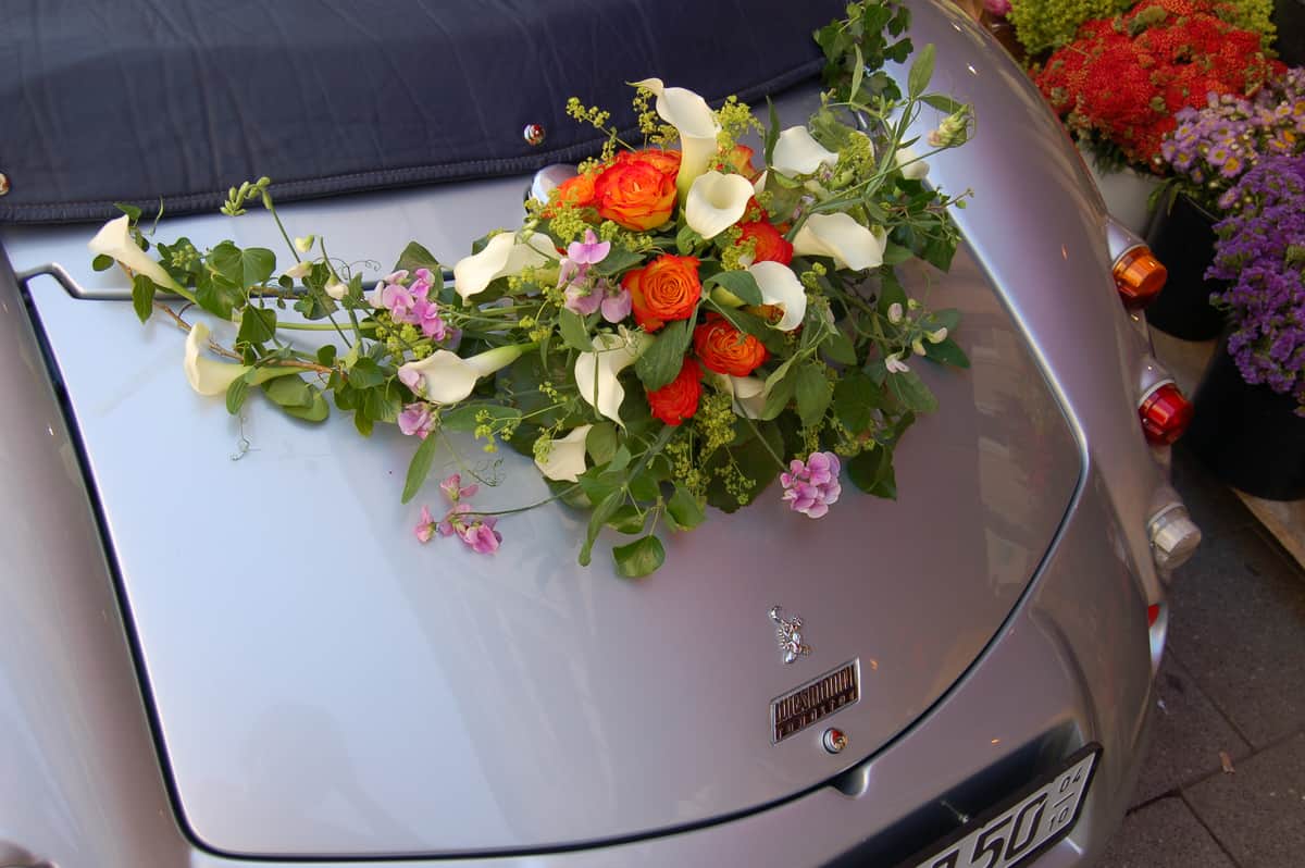 Autoschmuck mit orangen Rosen und Calla auf Oldtimer