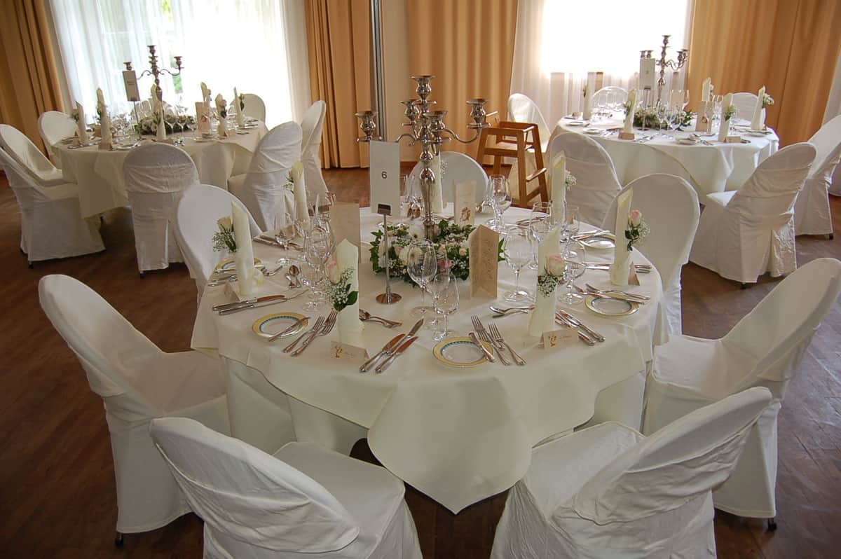 Festsaal mit runden Tischen und Blumendekoration