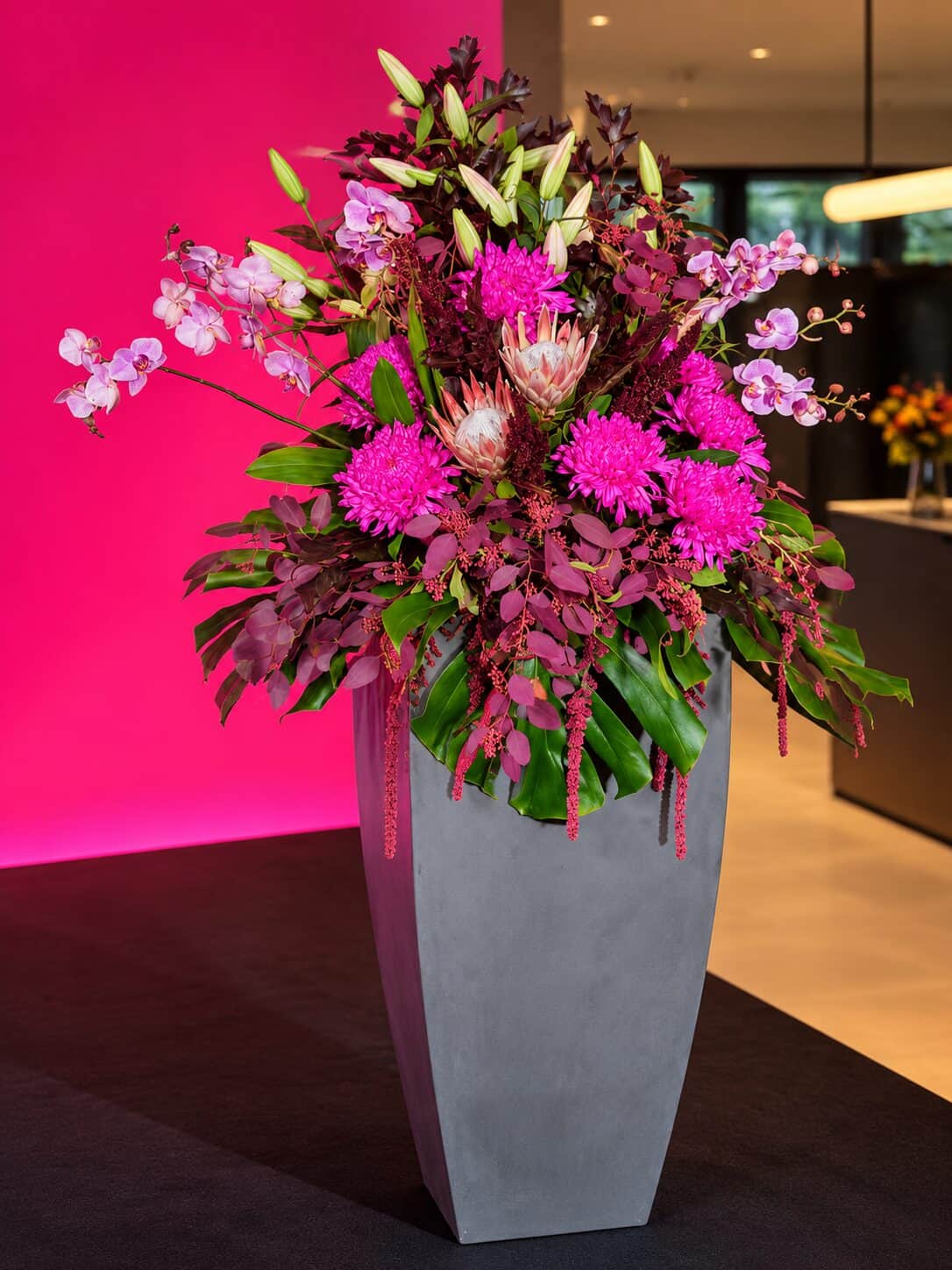 Moderne Blumenarrangements in Magenta und Burgunder beim Innovation Day im House of Communication München (2/8)