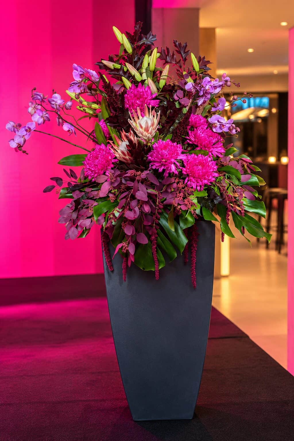 Moderne Blumenarrangements in Magenta und Burgunder beim Innovation Day im House of Communication München (3/8)