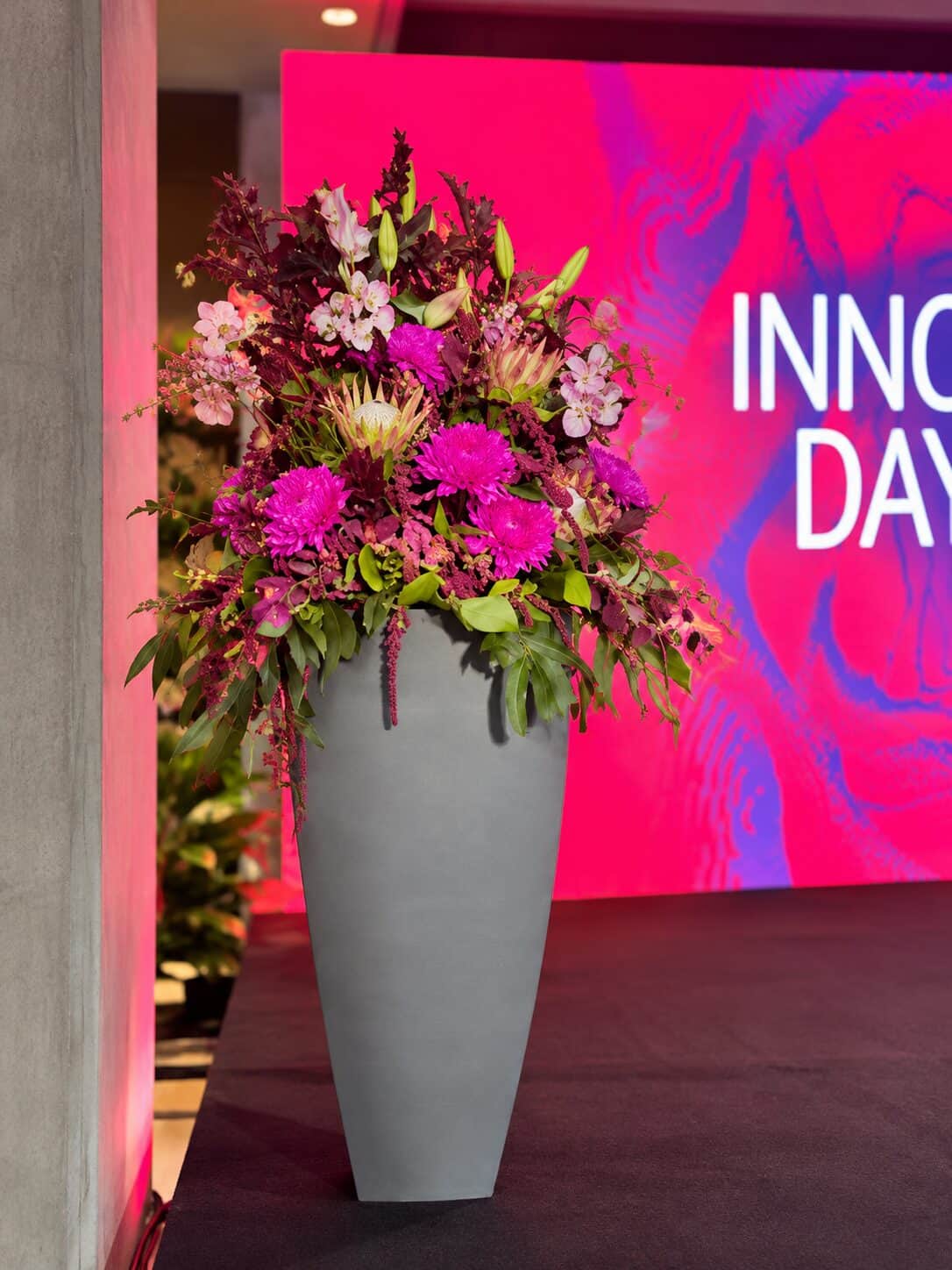 Moderne Blumenarrangements in Magenta und Burgunder beim Innovation Day im House of Communication München (6/8)