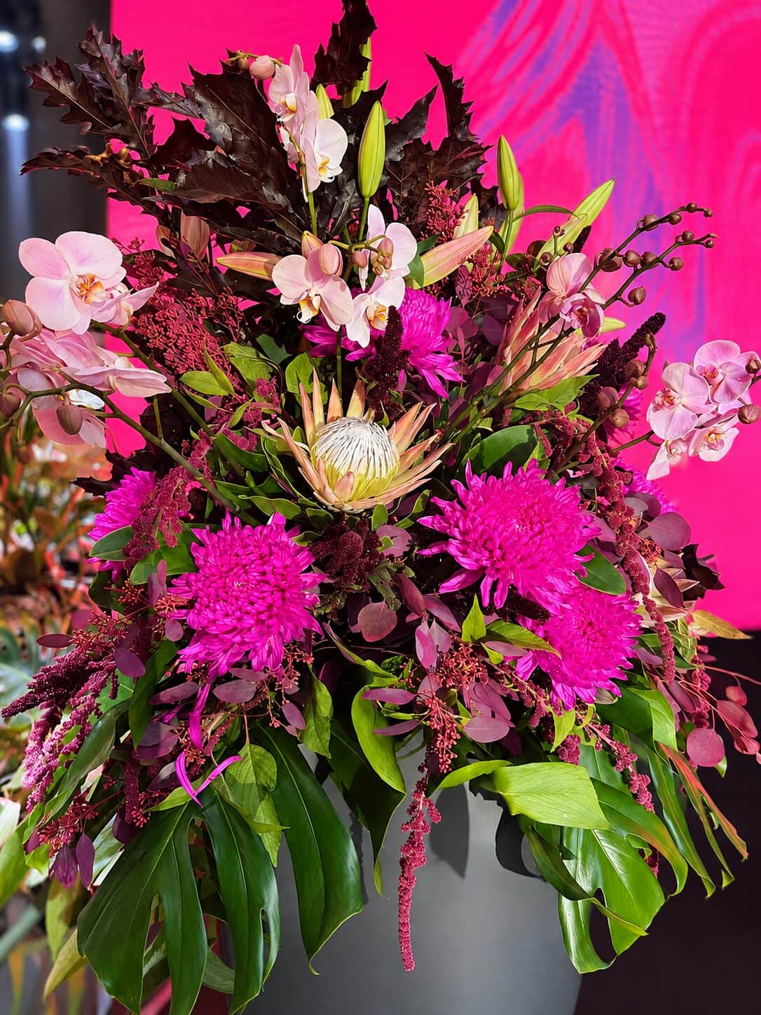 Moderne Blumenarrangements in Magenta und Burgunder beim Innovation Day im House of Communication München (7/8)
