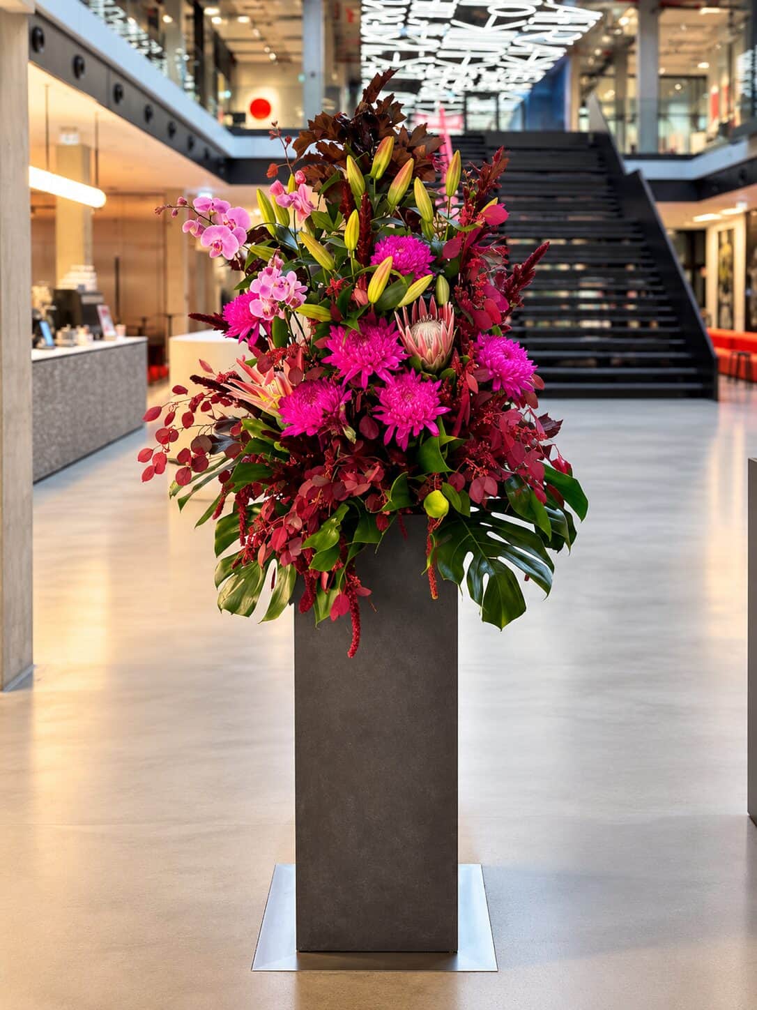 Moderne Blumenarrangements in Magenta und Burgunder beim Innovation Day im House of Communication München (8/8)