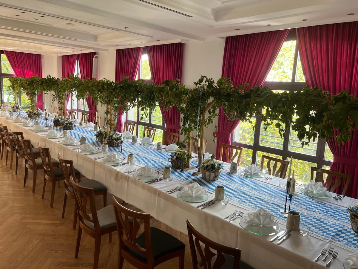 Bayerisch dekorierte Festtafel mit Hopfengirlanden und blau-weisser Tischdecke