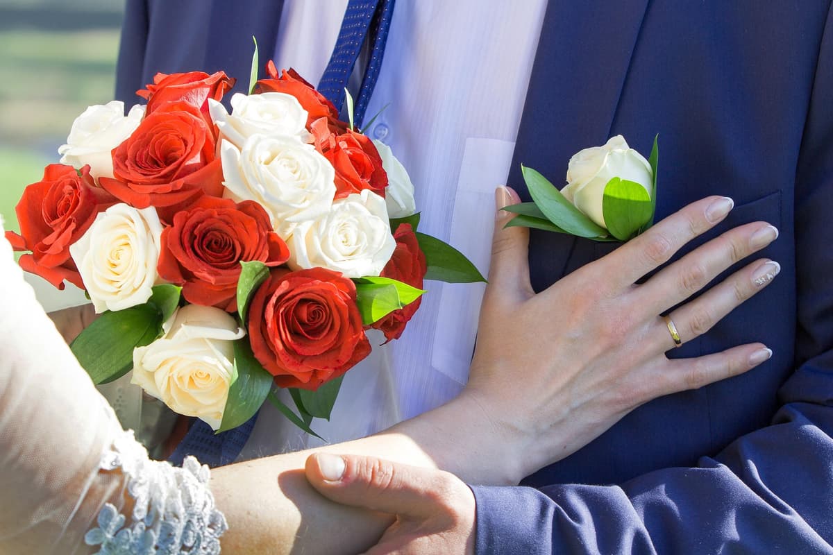 Kompakter runder Brautstrauß aus roten und weißen Rosen