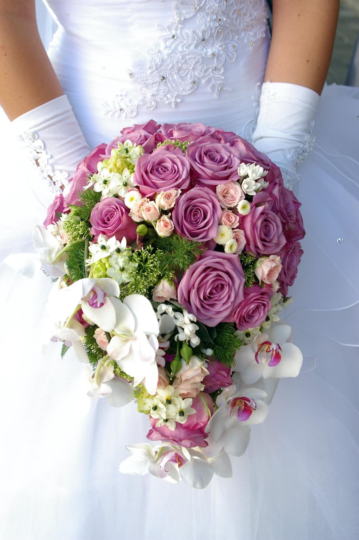 Abfließender Brautstrauß mit lila Rosen und weißen Orchideen