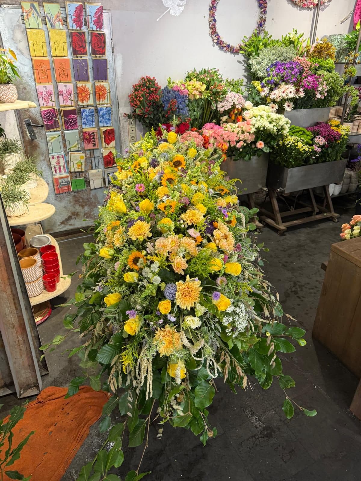 Üppiges gelbes Sargbukett mit Sonnenblumen auf dem Sarg