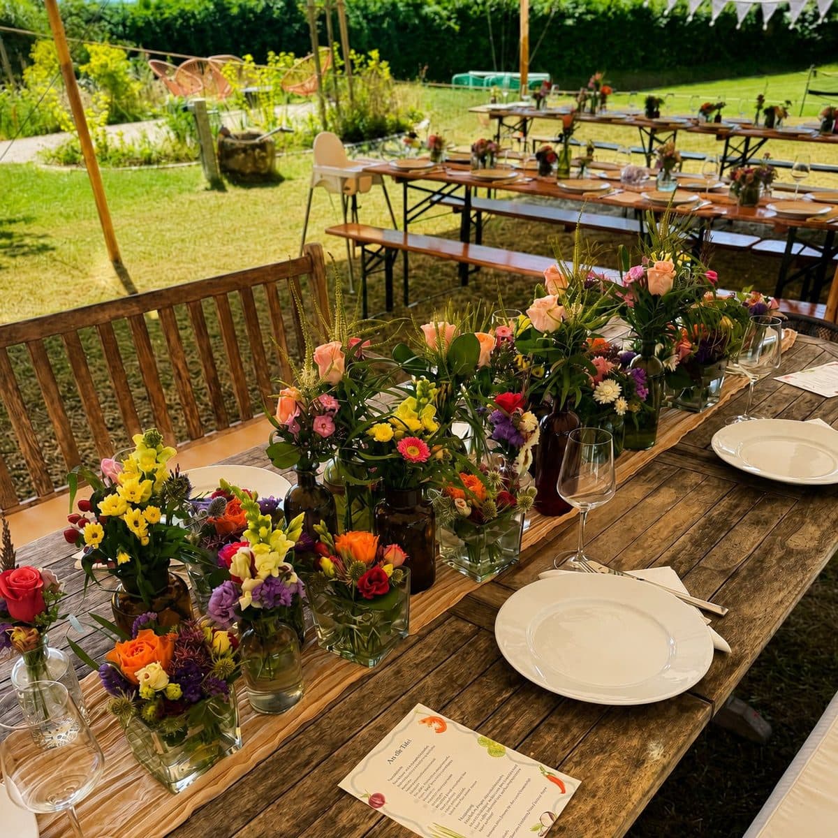Bunte Tischsträußchen aus Sommerblumen in kleinen Glasvasen